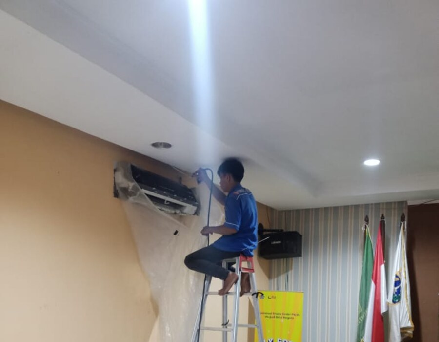 Teknisi mencuci unit indoor AC