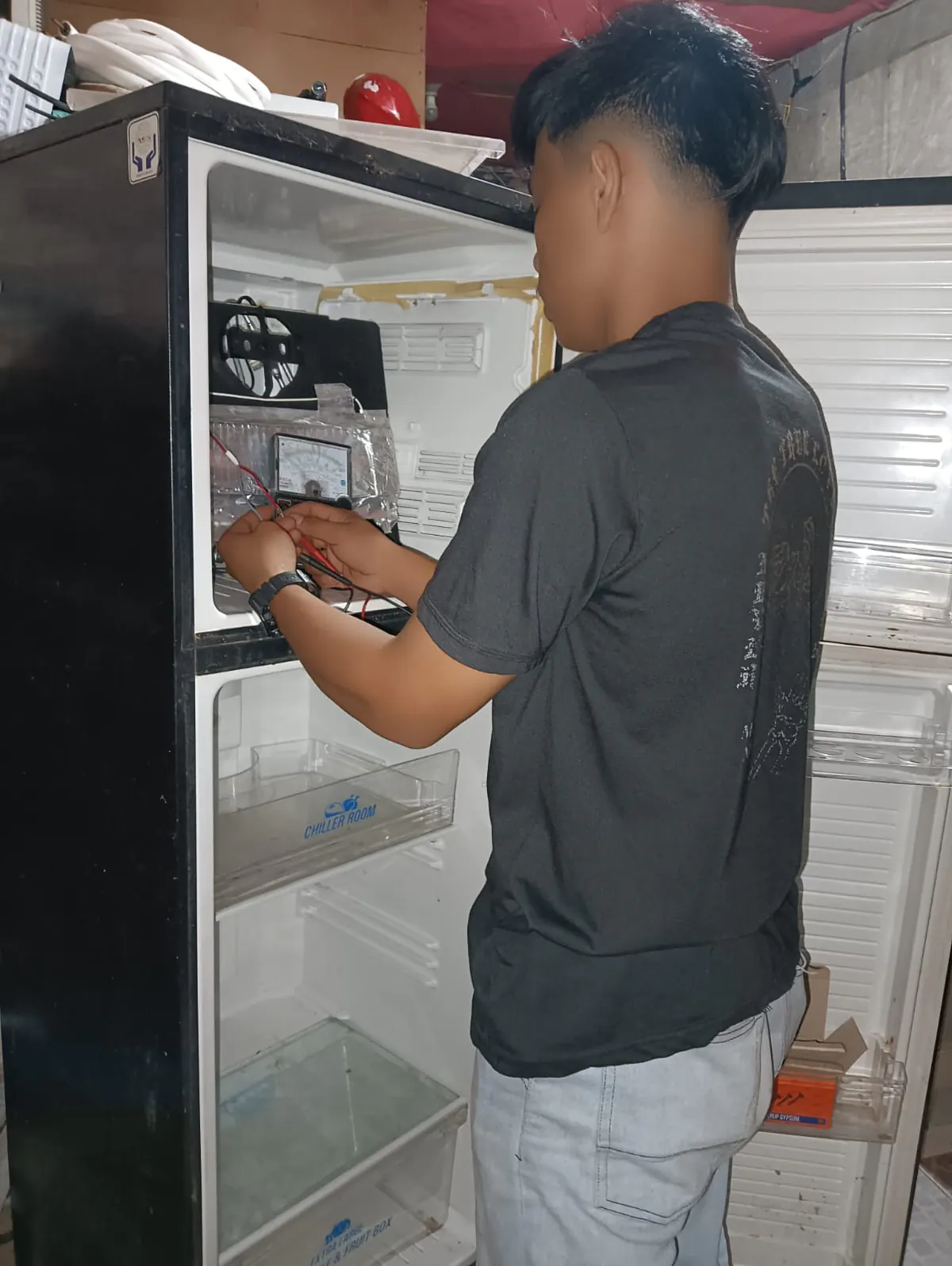 Teknisi memperbaiki kulkas dua pintu